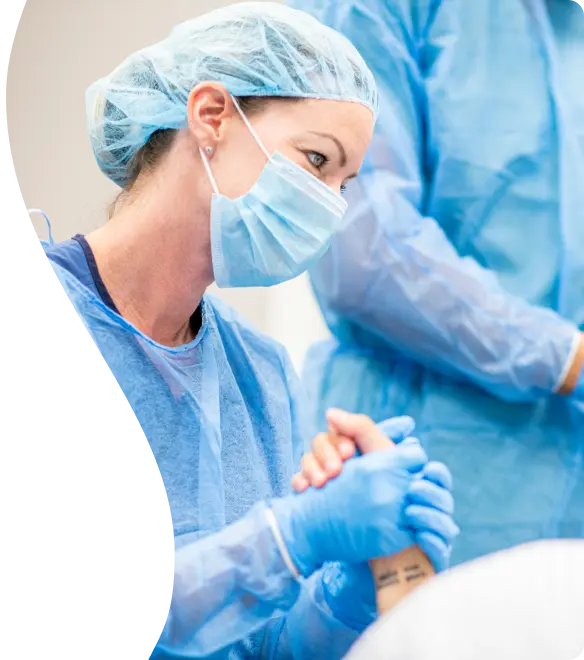 A female surgeon wearing a mask and gloves
