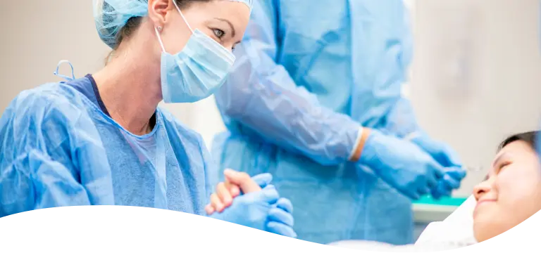 A female surgeon wearing a mask and gloves